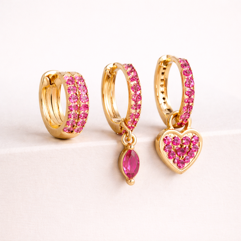 The Cara SET's three gold hoops are shown close up, each lined with pink pave crystals and dangling charms.