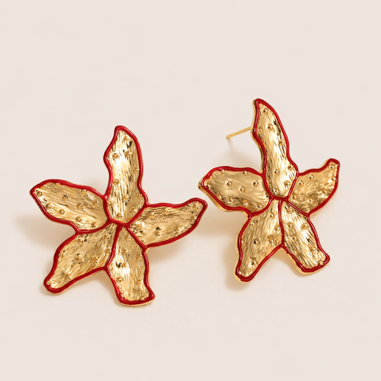 Gold Carrie EARRINGS studs shaped like a textured starfish with a red enamel outline along each petal.