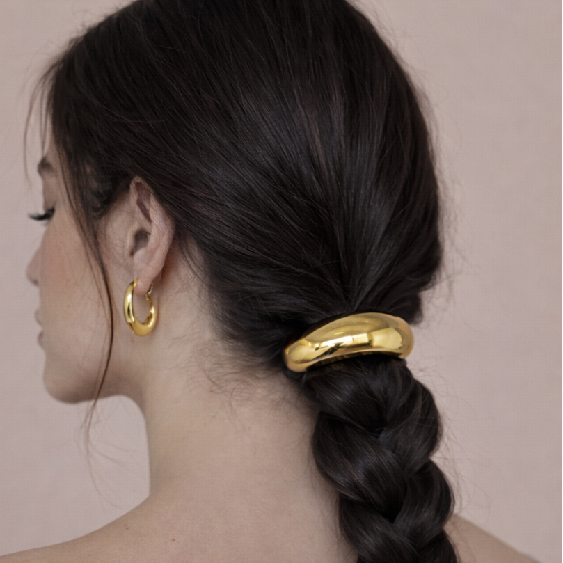 Cecil Hair Tie worn on a braided ponytail, gold bead accent on dark hair, gold hoop earrings.