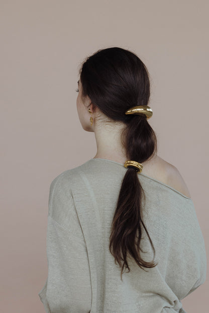 Cecil Hair Tie worn stacked, two gold clips on a low ponytail, model in a sage green sweater.