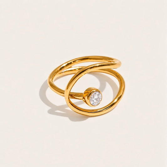 Gold Cercle RING: a slim band looping into an open circle that frames a white zirconia stone — Folie à Trois