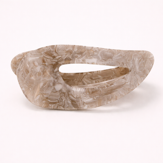 Clara HAIR CLIP wave-shaped acetate barrette in a beige and brown marbled pattern, studio shot.