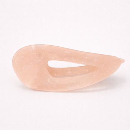 Clara HAIR CLIP wave-shaped acetate barrette in a soft peach-pink shade, studio shot.