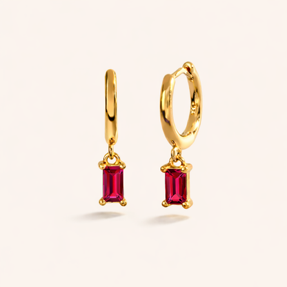 Classic Drop Earrings in gold with ruby-pink crystals, a smooth hoop dropping a single baguette-cut stone.