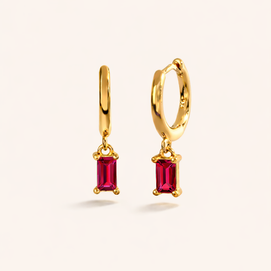 Classic Drop Earrings in gold with ruby-pink crystals, a smooth hoop dropping a single baguette-cut stone.