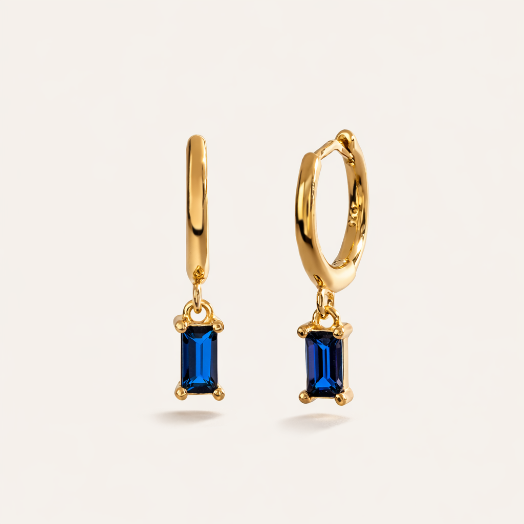 Classic Drop Earrings in gold with sapphire-blue crystals, showing the hoop and baguette-cut crystal drop.