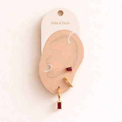 The Classic Drop SET in a garnet red colorway displayed on a branded Folie à Trois ear card with the stud, pavé hoop, and dangle hoop.