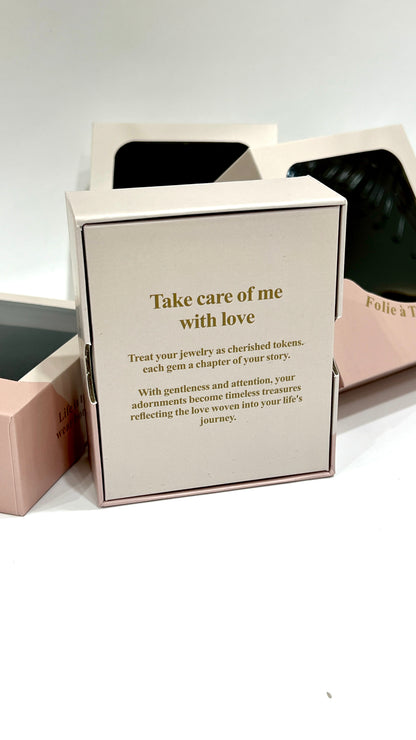 Open Folie à Trois gift box lid printed with a take care of me with love message about cherishing your jewelry.