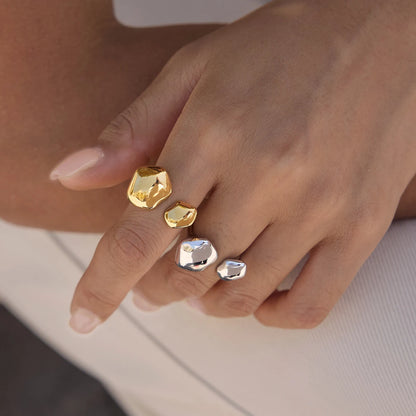 Hand wearing gold and silver-tone Cloud RINGS with organic pebble shapes, stacked on two fingers — Folie à Trois