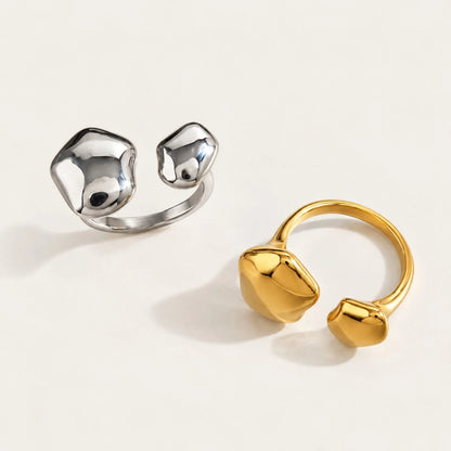 Two Cloud RINGS in silver-tone and gold with smooth, organic pebble-shaped ends on a cream background — Folie à Trois