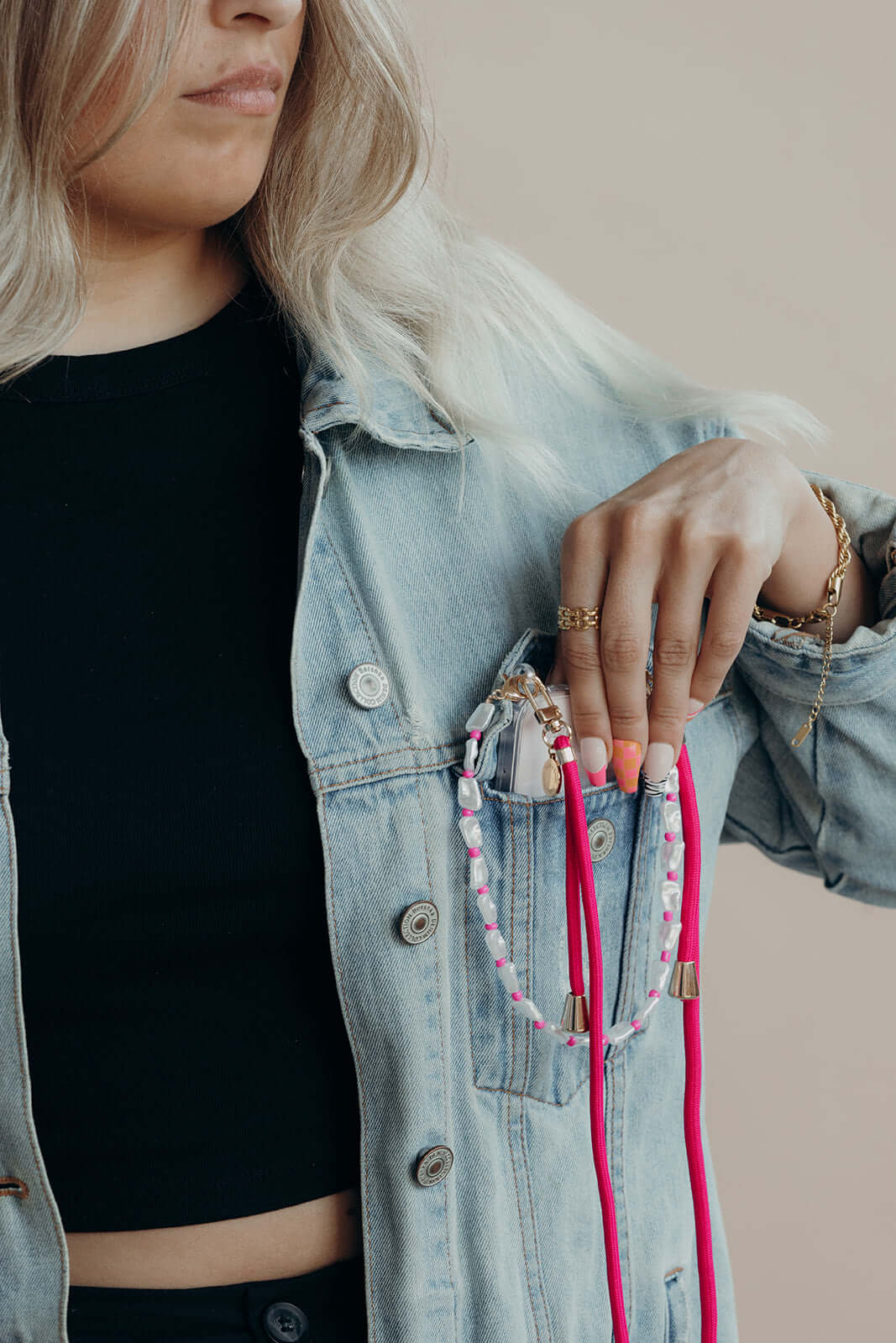 Pink and white beaded phone straps tucked in a denim jacket pocket, styled with the Colorful PHONE CORD collection.