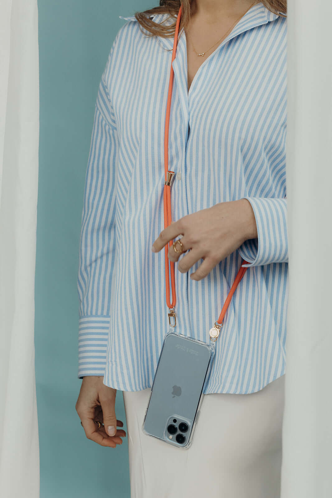 Orange Colorful PHONE CORD with a clear phone case tucked into a model's striped shirt pocket.