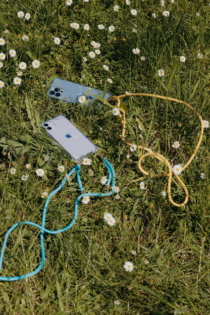 Sky blue and mustard yellow Colorful PHONE CORDs with two phones laid in a field of daisies.
