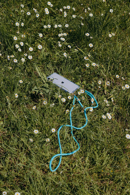 Turquoise Colorful PHONE CORD with a phone laid in a sunlit field of white daisies.