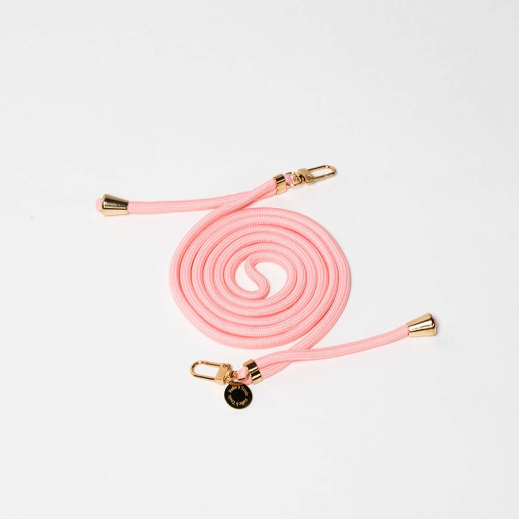 Light pink Colorful PHONE CORD coiled with gold-tone hardware on a white background.