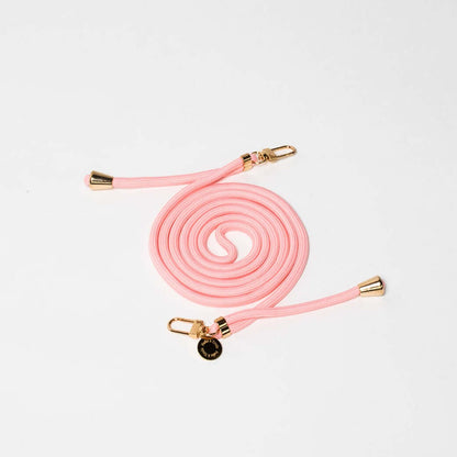 Light pink Colorful PHONE CORD coiled with gold-tone hardware on a white background.