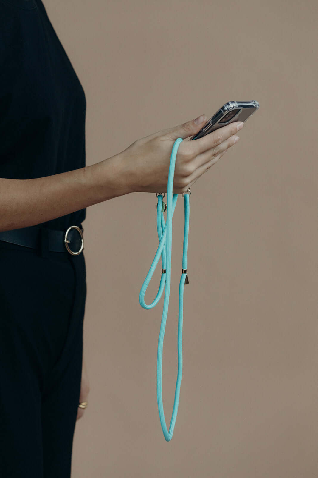 Teal Colorful PHONE CORD, model holding her phone in hand against a tan background.