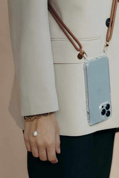 Tan Colorful PHONE CORD, phone worn on the hip over a beige blazer with a pearl bracelet.