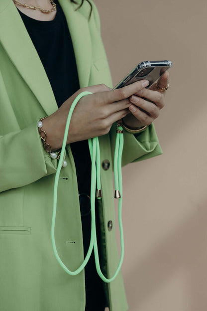 Mint green Colorful PHONE CORD, model in a green blazer holding her phone in hand.