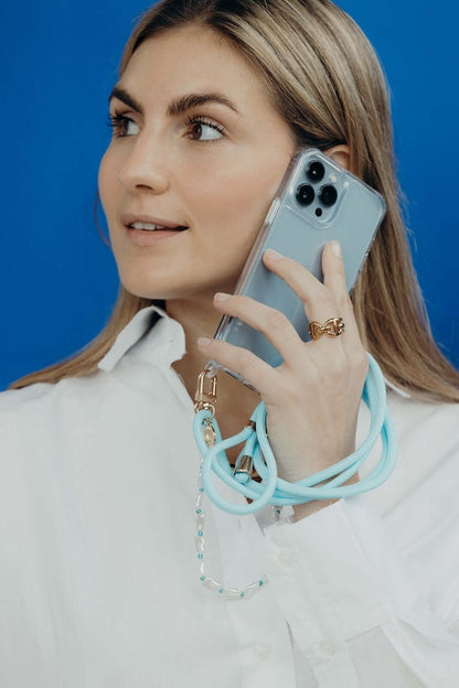 Light blue Colorful PHONE CORD, model on a phone call against a bright blue background.