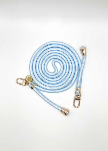 Pale blue and white Colorful PHONE CORD coiled with gold-tone hardware on a white background.