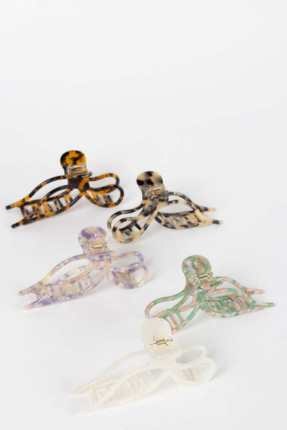 Coquette HAIR CLIP five bow-shaped claw clips shown together across amber, dark tortoise, lilac, green-pink and cream colorways, studio shot.
