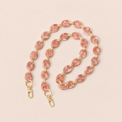 Pink marbled coin-link phone chain with gold connectors coiled on cream — Folie à Trois Corvin wholesale phone chain