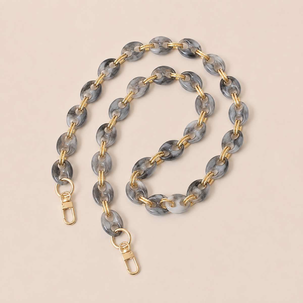 Charcoal marbled coin-link phone chain with gold connectors coiled on cream — Folie à Trois Corvin wholesale phone chain