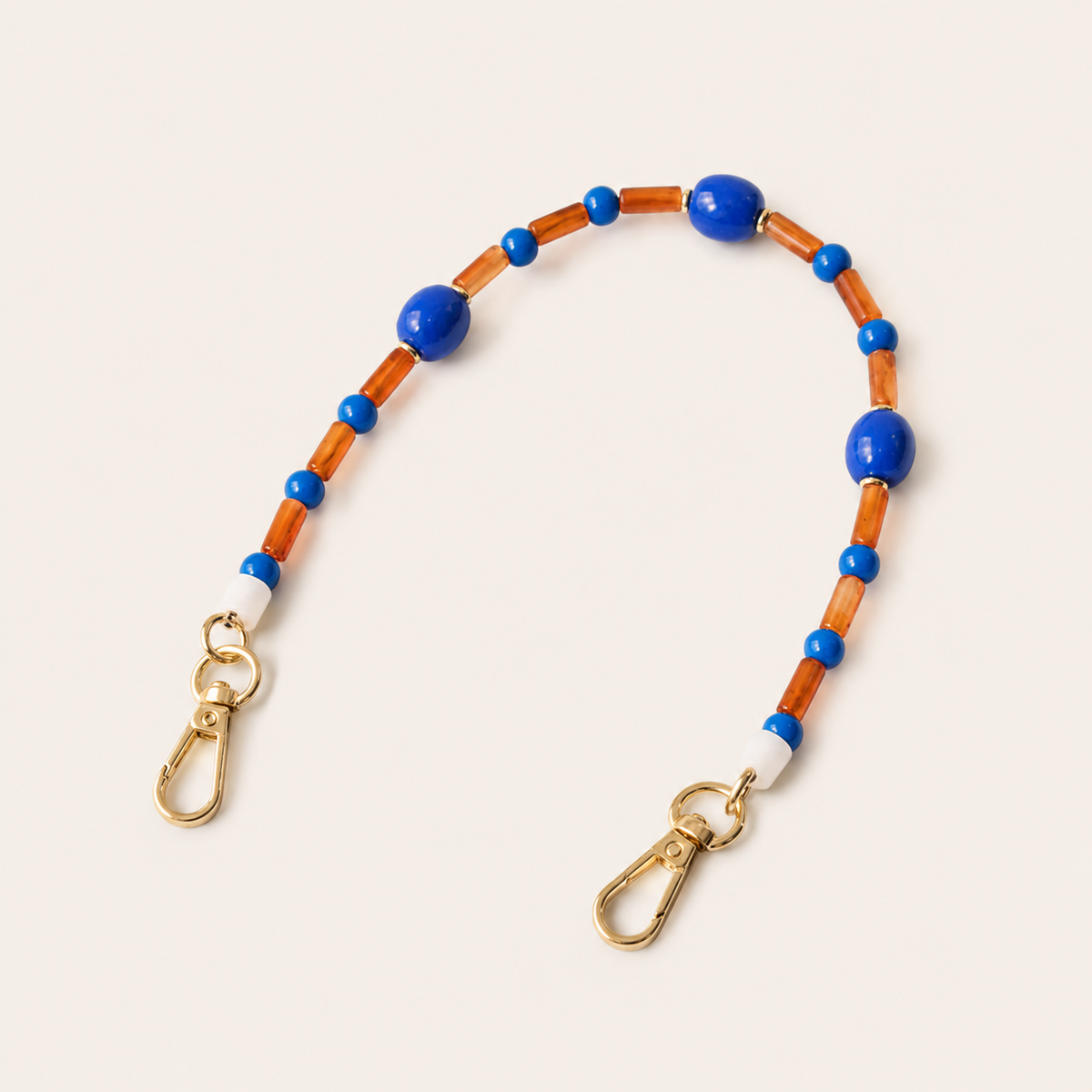 Blue and amber beaded Cosmo short phone strap coiled flat with gold-tone clasp ends.