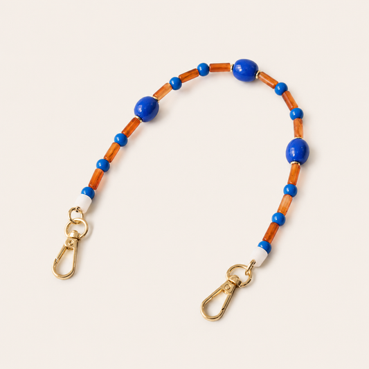 Blue and amber beaded Cosmo short phone strap coiled flat with gold-tone clasp ends.