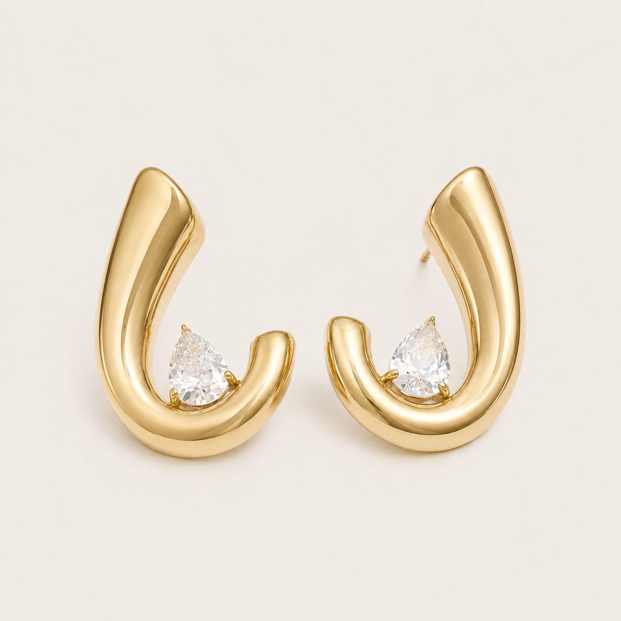 Gold curved crescent hoop earring with a pear-cut white zirconia stone nestled at the base — Folie à Trois Crescent EARRINGS.