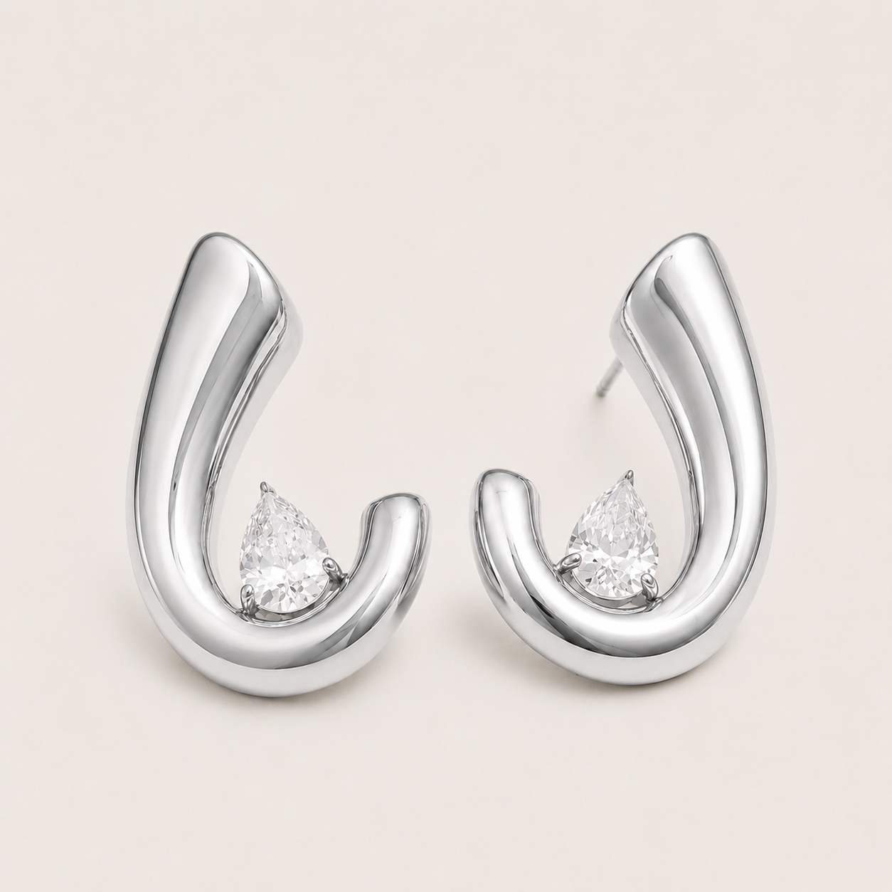 Silver curved crescent hoop earring with a pear-cut white zirconia stone nestled at the base — Folie à Trois Crescent EARRINGS.