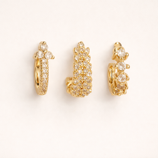 Daisy Set of gold hoops, a pave hoop with a flower cluster top, a fully pave leaf-shaped hoop, and a graduated stone hoop.