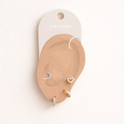 Illustrated Folie a Trois earring card showing the Delia Set pieces arranged on an ear-shaped display.