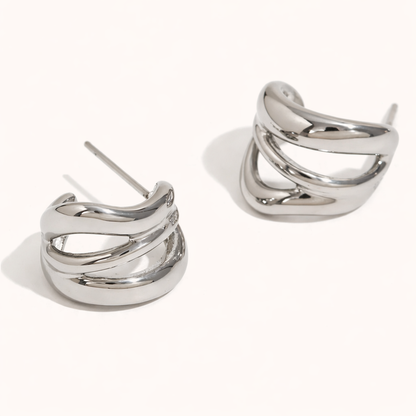 Delphi Earrings in polished silver, a chunky wide hoop formed by twisting interlaced bands for a sculptural finish.