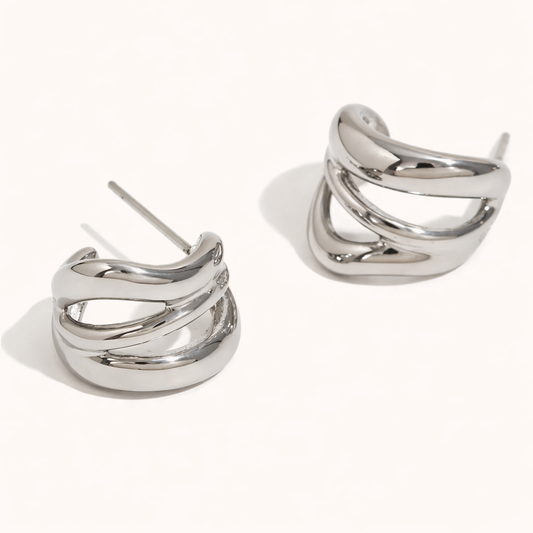 Delphi Earrings in polished silver, a chunky wide hoop formed by twisting interlaced bands for a sculptural finish.