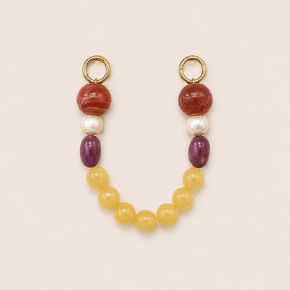 Red, pearl, purple, and yellow bead phone chain with gold hoop clasps laid flat on cream — Folie à Trois Delphine wholesale phone chain