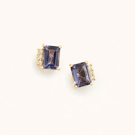 Devon Earrings feature a large emerald-cut purple stone accented by three small clear stones on gold prongs.
