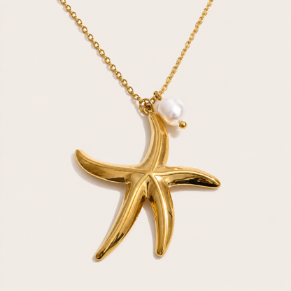 Gold chain necklace with a polished starfish pendant and pearl accent from the Dolce Mare NECKLACE design, laid flat.