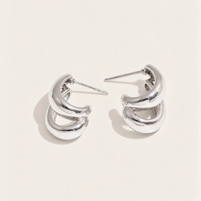 Silver-tone Doppia EARRINGS: a pair of hoops formed by two smooth C-shaped curves layered together — Folie à Trois