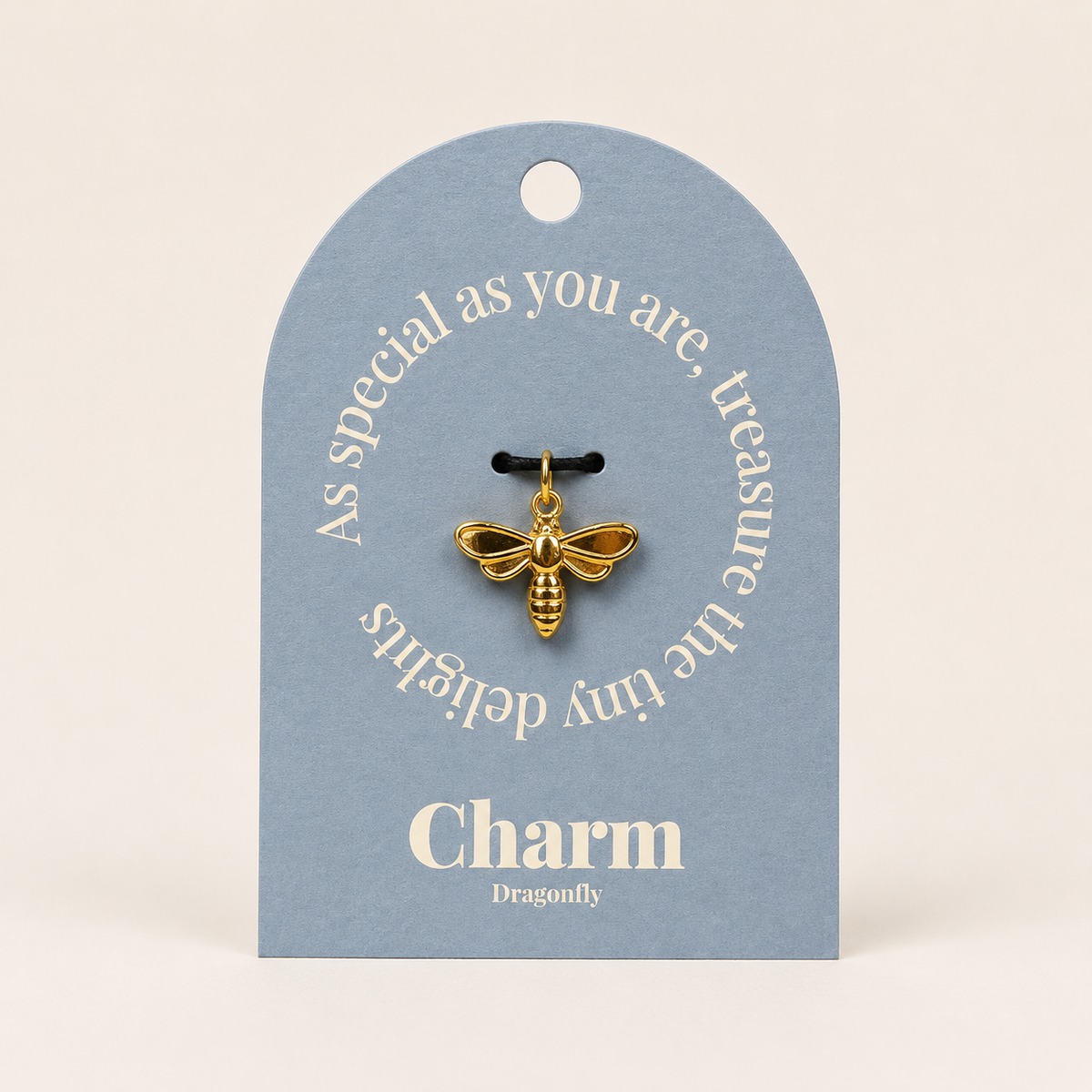 The Dragonfly CHARM displayed on a dusty blue Charm gift tag, hanging from a black cord against the card text As special as you are.