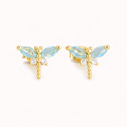 The Dragonfly EARRINGS are gold studs shaped like dragonflies, with blue marquise crystal wings and a beaded body.