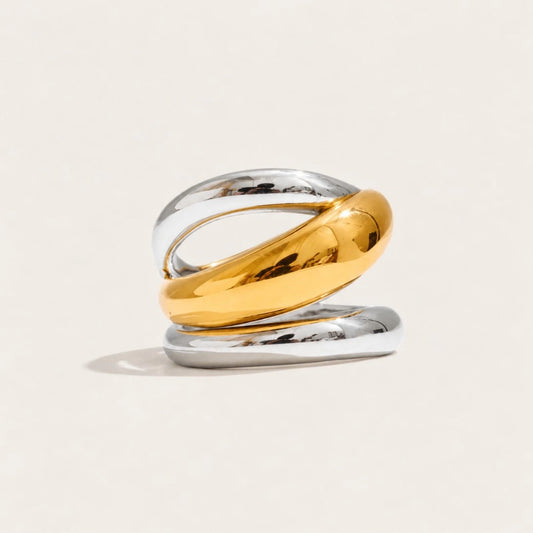 Two-tone Duetto RING: a hollow spiral band with a gold-tone wrap curling over a silver-tone base — Folie à Trois