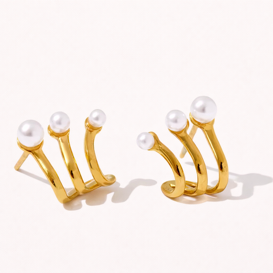 Effie Earrings in gold, three curved prongs each topped with a graduated pearl, fanning out from the lobe like a claw design.