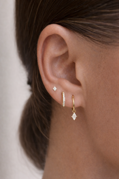 Close-up of the Eira Set worn on the ear, showing the kite-shaped stud, pave hoop, and huggie hoop with a diamond drop.