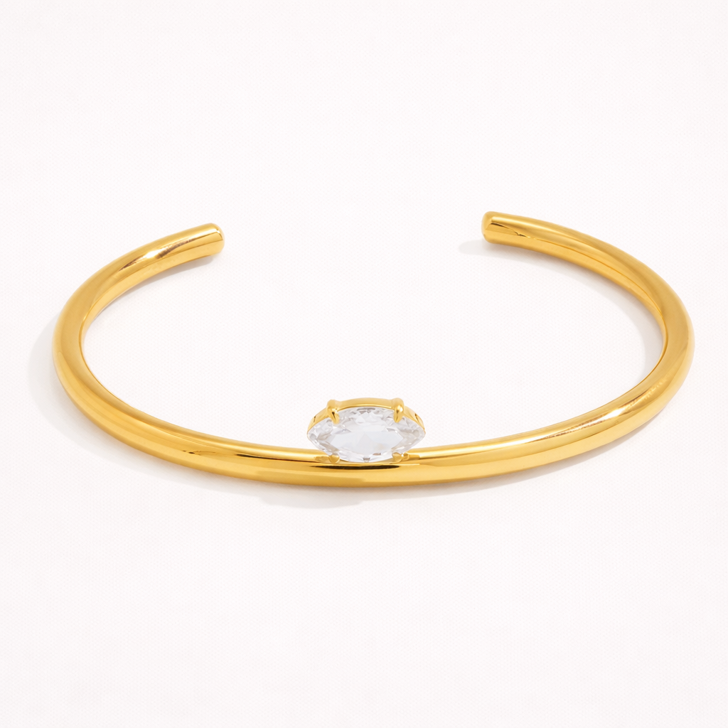Electric Frost BRACELET in gold, a slim open cuff with a single marquise crystal, shown alone on white.