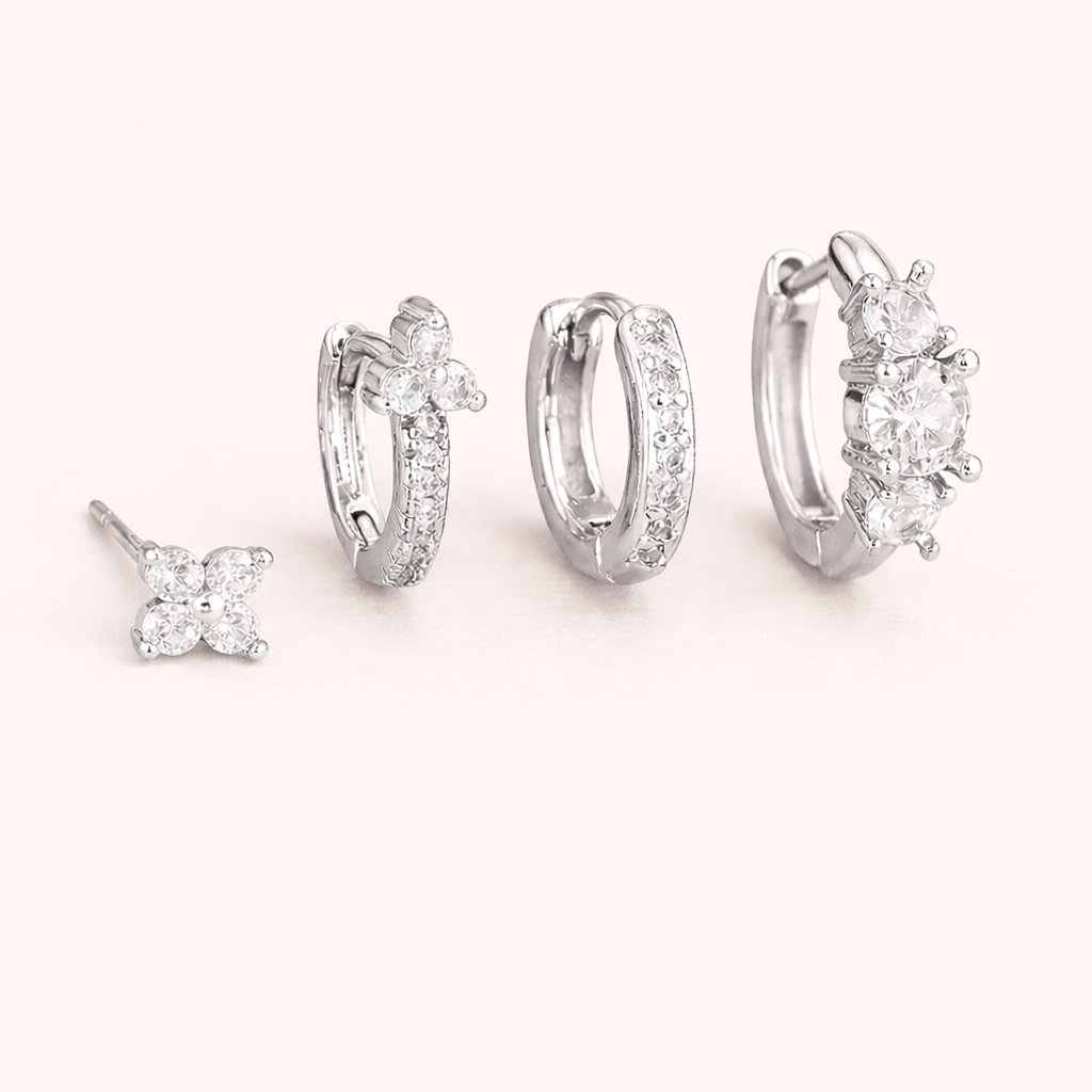 The Elle SET is shown in silver: a clover stud, a flower-topped pave hoop, a plain hoop, and a cluster huggie.