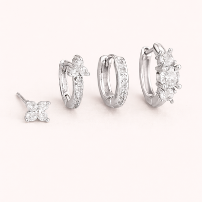 The Elle SET is shown in silver: a clover stud, a flower-topped pave hoop, a plain hoop, and a cluster huggie.