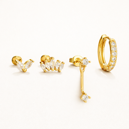 Elodie Set of four gold pieces: a marquise cluster stud, a wider marquise crown stud, a crystal drop stud, and a pave huggie hoop.