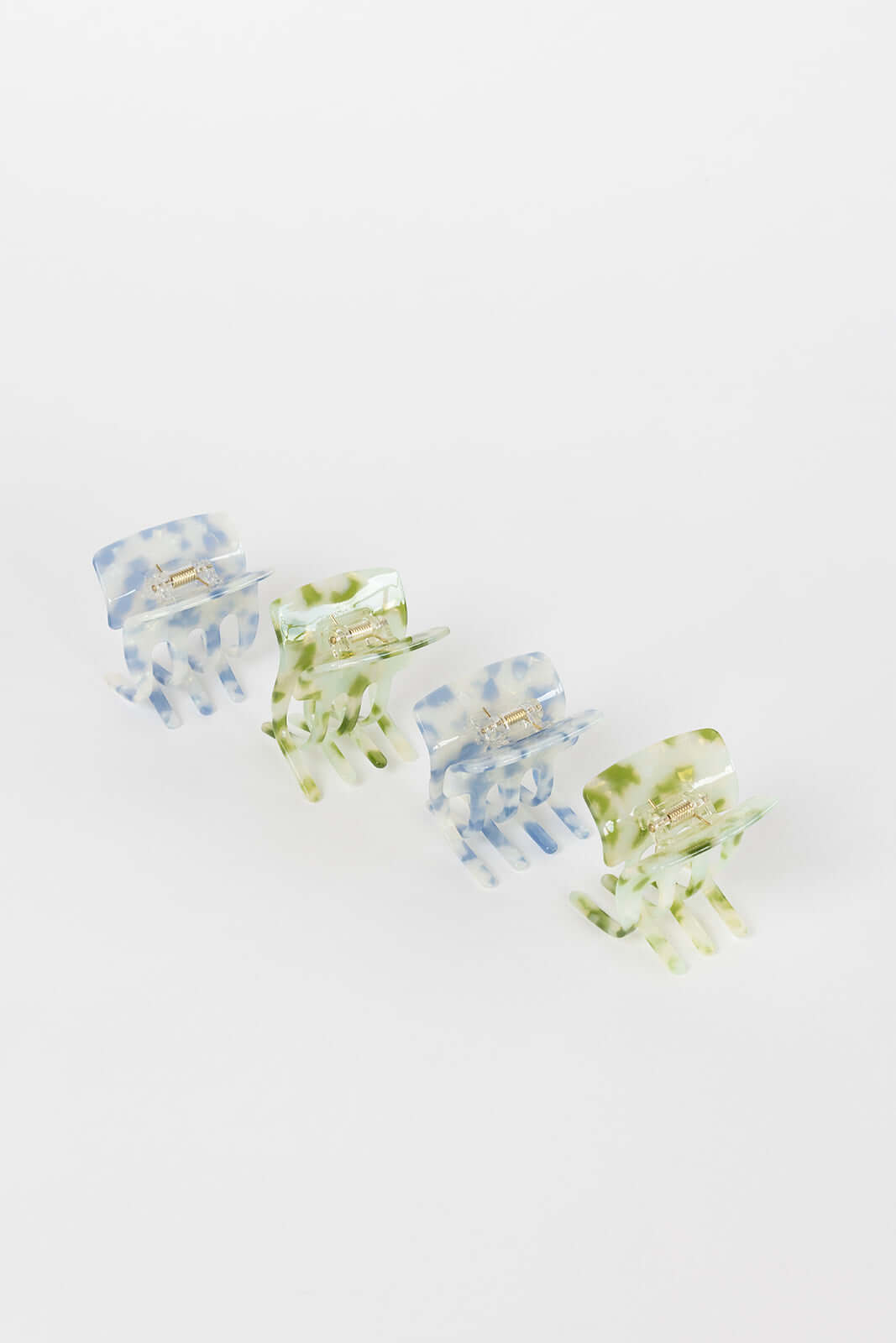Enchanted Garden HAIR CLIP four claw clips arranged diagonally in blue and green marbled colorways, studio shot.